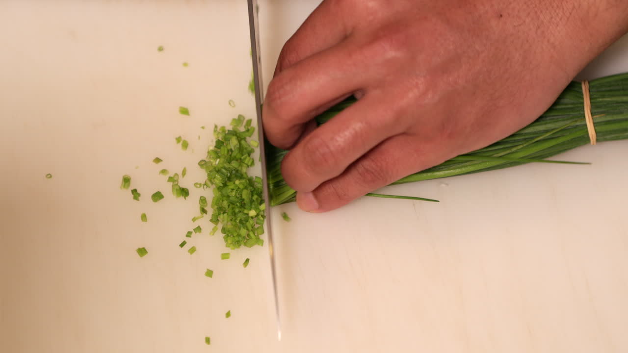 Chef Chopping Green Chives For Sushi At The Kitchen - overhead slowmo shot