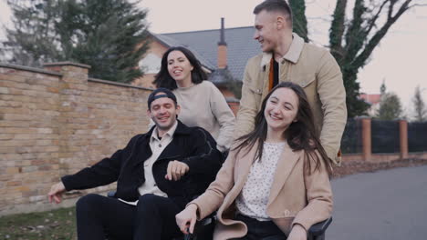 woman and man running with her disabled friends in wheelchair and having fun together 1