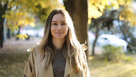 calm woman between trees in bright sunlight on the background