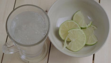 Verter-Un-Vaso-De-Agua-Fresca-Con-Gas,-Rodajas-De-Limón.