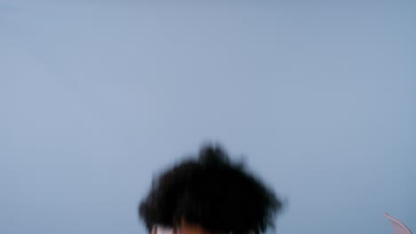 young black woman with curly hair and brown eyes poses in various playful ways, smiling to camera.
