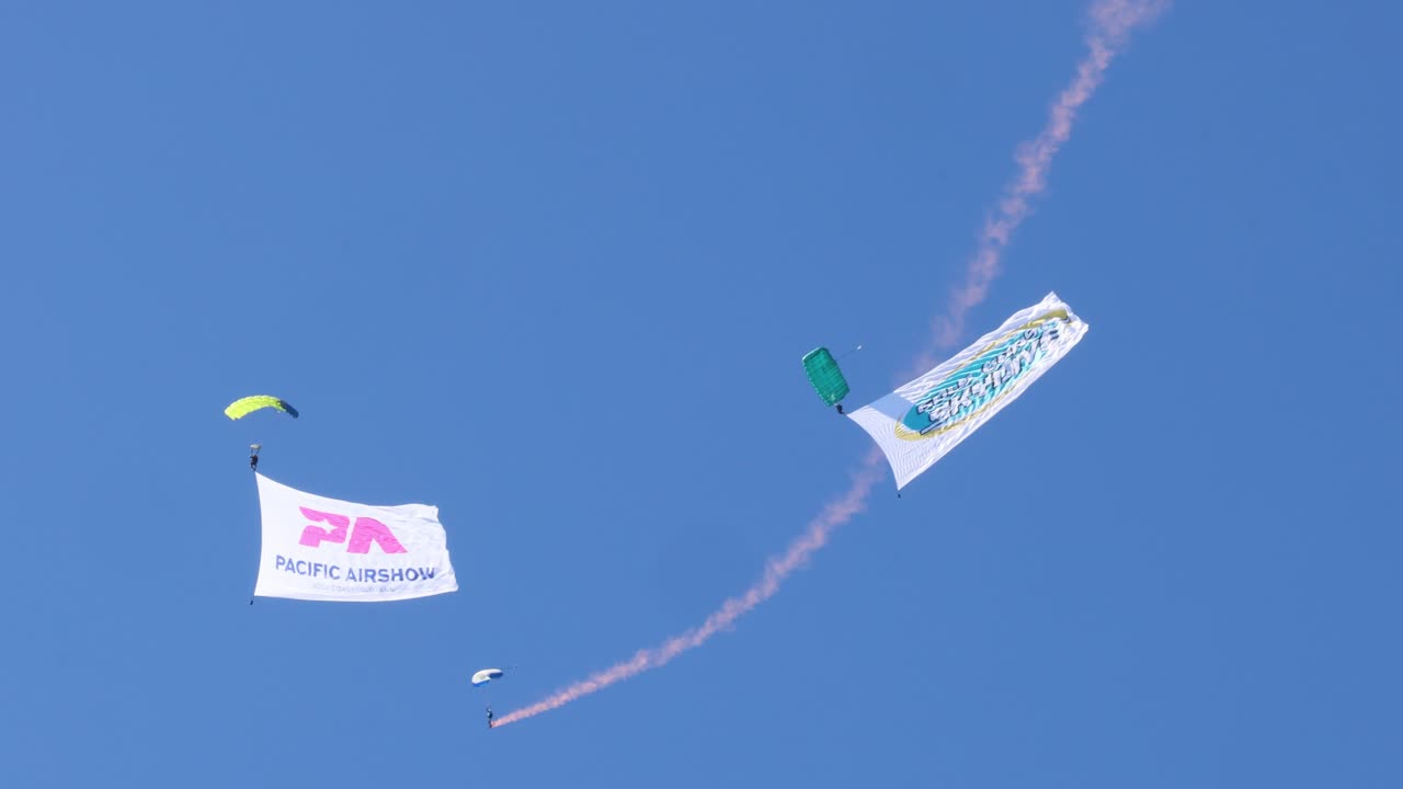 Colorful banners towed by planes against clear sky