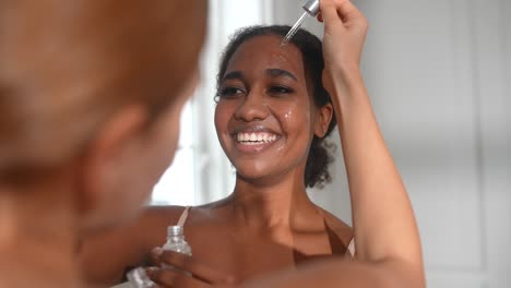 woman applying face serum
