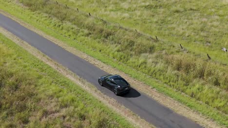 un coche viaja lentamente a través de tierras de cultivo rurales