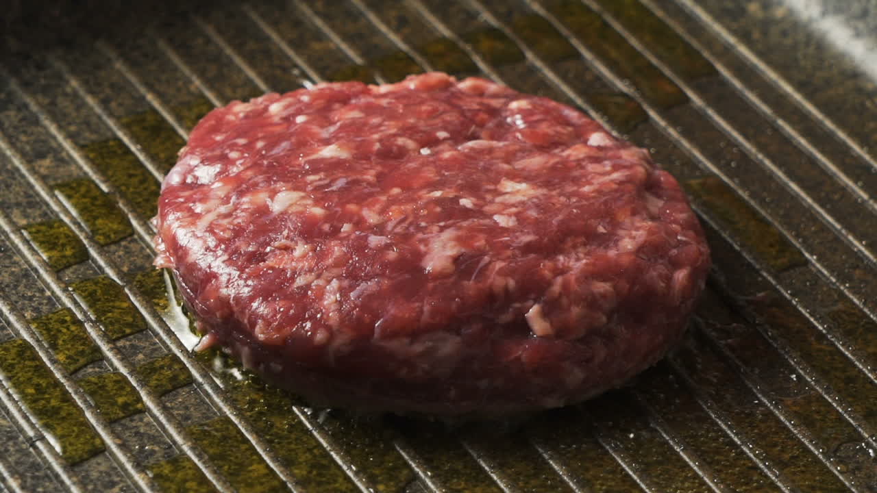 Raw burger patty on the grill