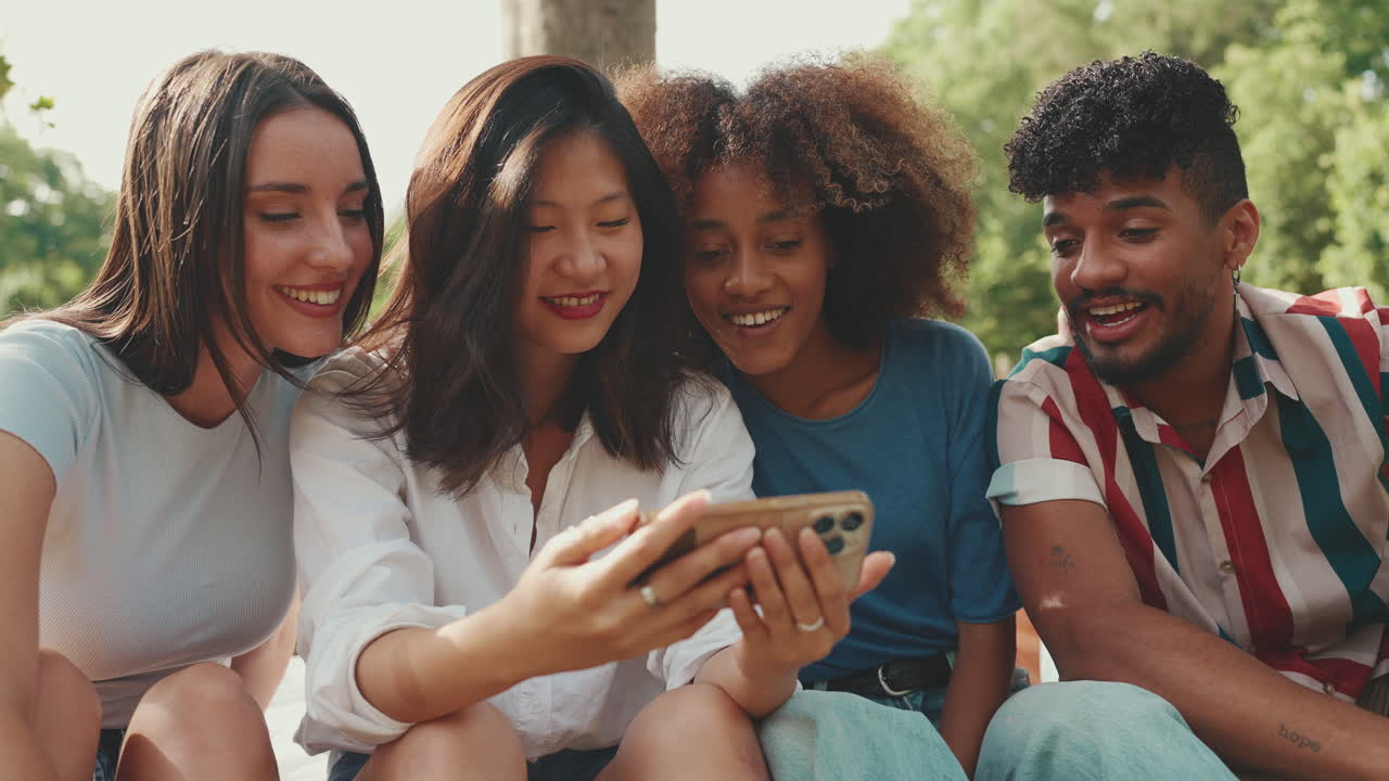 Amici che guardano uno smartphone nel parco