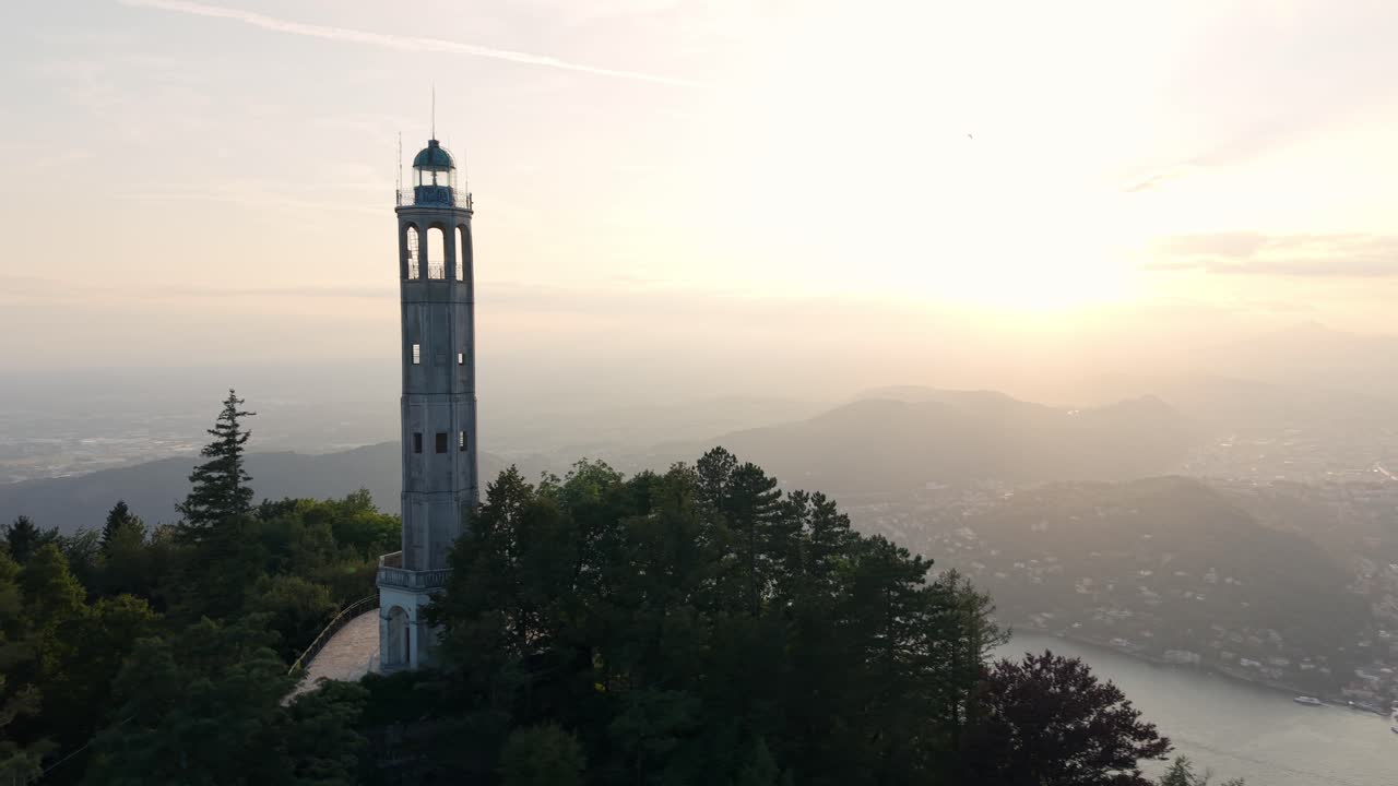 Der Leuchtturm Faro Voltiano ragt hoch auf dem Brunate-Hügel empor, mit einem strahlenden Sonnenuntergang im Hintergrund