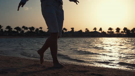 Barefoot-girl-walking-along-seashore.-Unrecognizable-woman-enjoying-sea-view.
