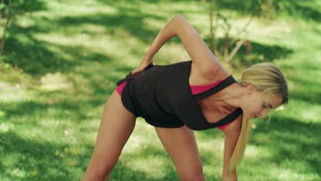 mujer rubia estirándose antes del entrenamiento al aire libre. corredora calienta