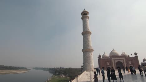 white tall taj mahal minaret overlooking the yamuna riverbank magnificence - pan tilt down reveal wide shot