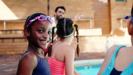 Niña-Sonriente-Sentada-Cerca-De-La-Piscina