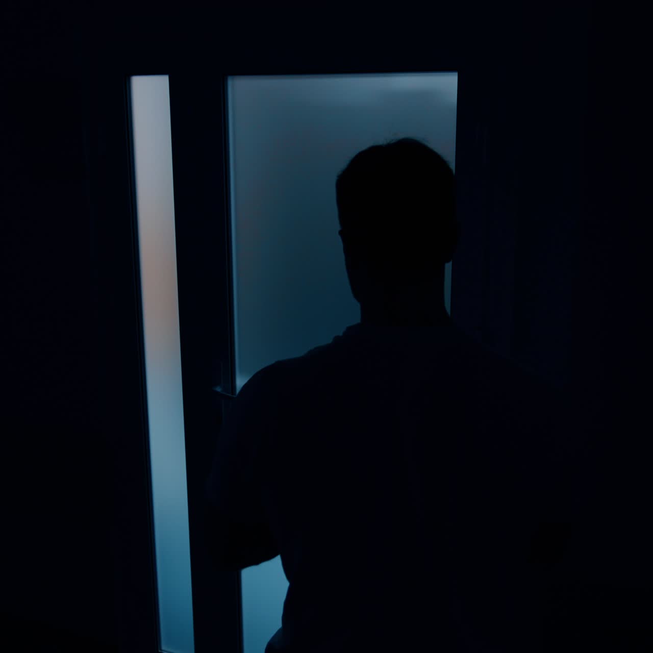 Male silhouette near the door to a delivery room. Worried husband waiting for his wife giving birth to a child