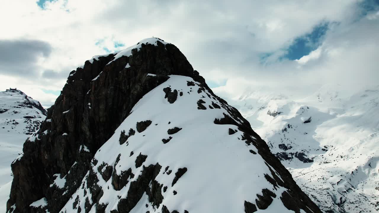 4k Drone Aerial Of Ridge and Peak Of Snow Covered Mountain With Glacier In The Distance In Zermatt Switzerland