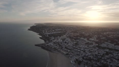 dusk glimmering wide horizon of algarve praia da luz coastline. aerial