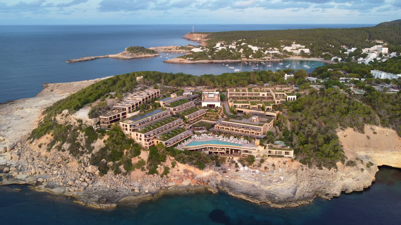Aerial flying backwards from Six Senses resort in Portinatx Bay, Ibiza, Spain
