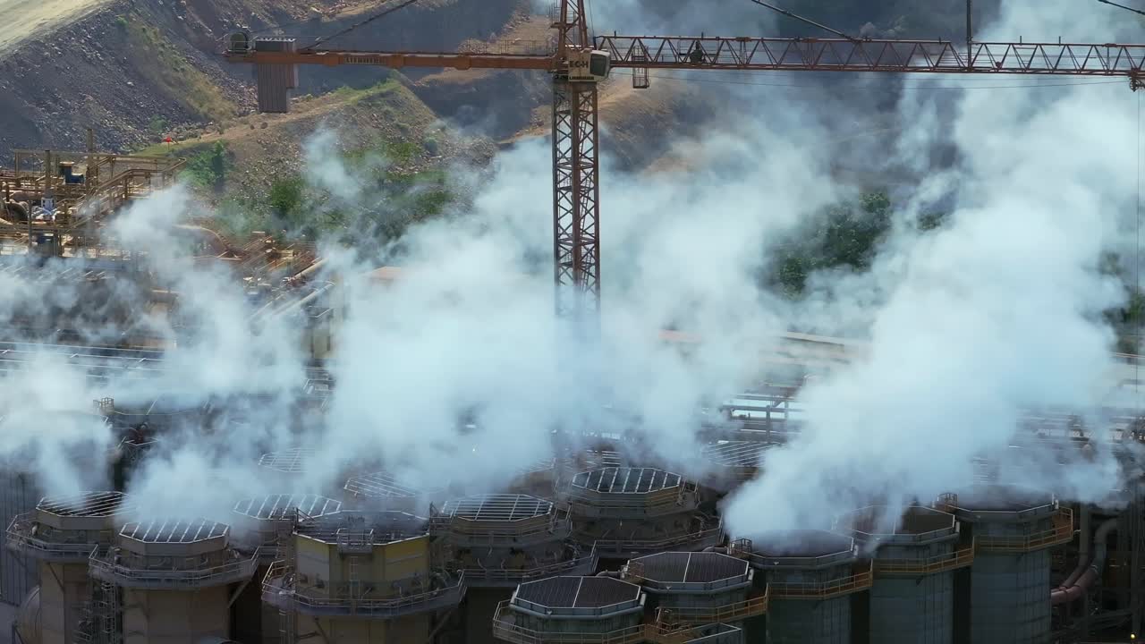 Smoke and steam billowing from Barrick Gold mining and processing facility in Cotui, Dominican Republic. Aerial drone static shot