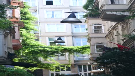 a narrow alleyway in a city with buildings on either side and streetlights hanging above