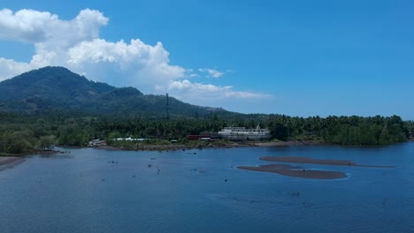 aerial drone view of an abandoned cruise shipwreck on an isolated tropical island with a dormant volcano in the foreground