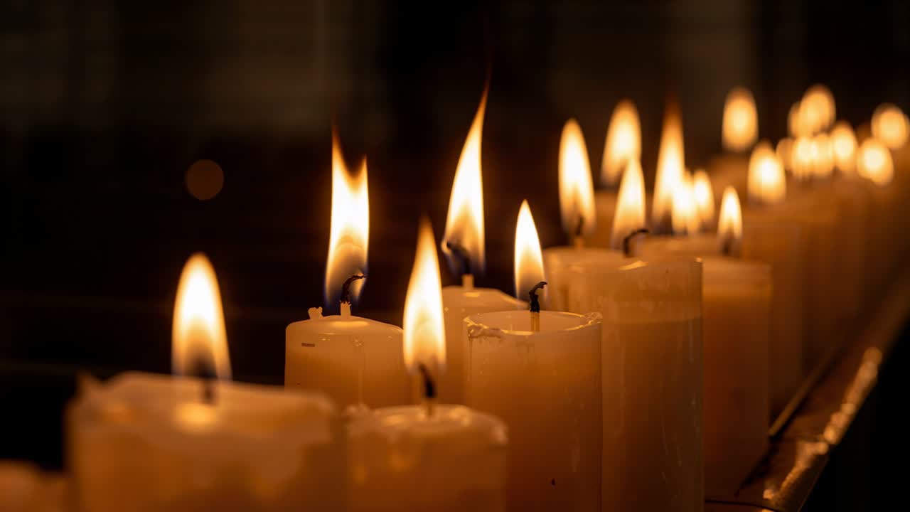 Una fila di candele a colonna che bruciano, con fiamme che si allungano e cera che si scioglie, creando una scena di interior design.