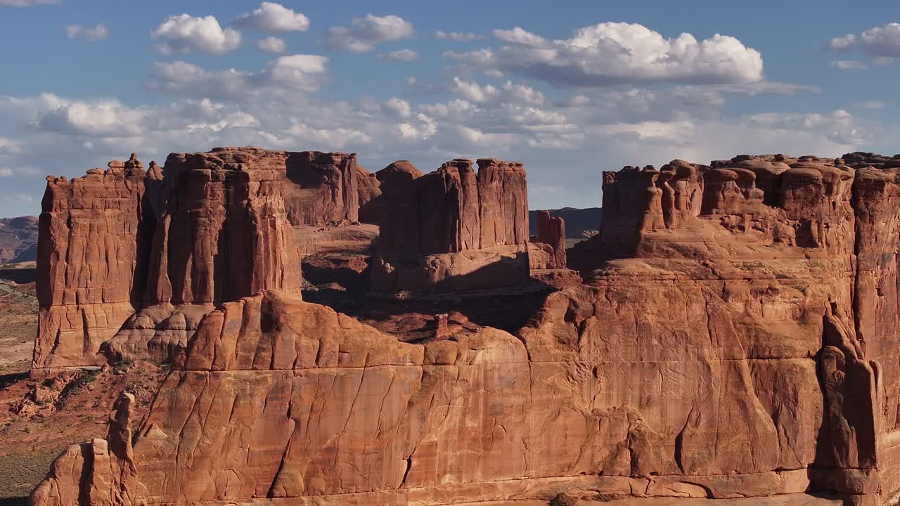 Spettacolari formazioni rocciose rosse con cielo azzurro e nuvole sparse a Moab, Utah