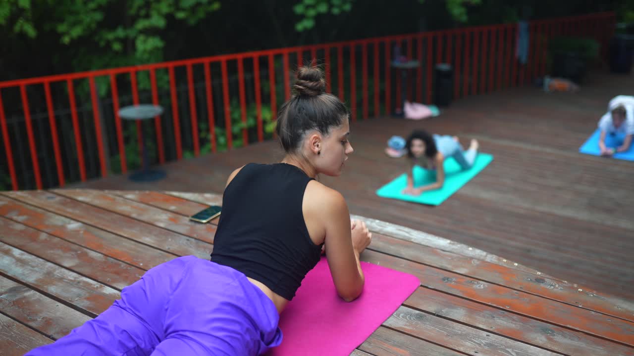 clase de yoga al aire libre en una cubierta de madera