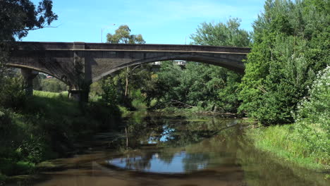 aerial towards historic cement arched bridge over moorabool river geelong