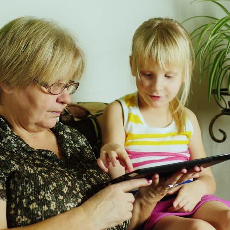 Grandma-And-Granddaughter-Using-Tablet-Together-01