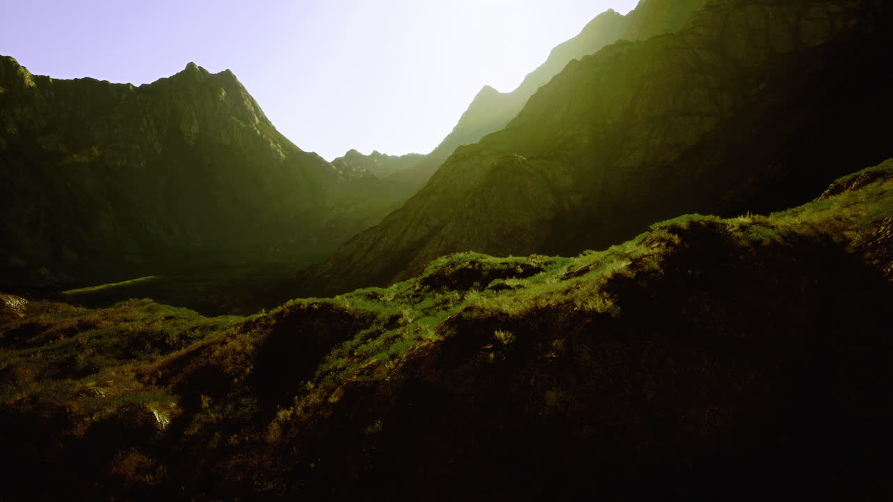 Mountain landscape at sunrise showcasing vibrant greenery and rocky terrain