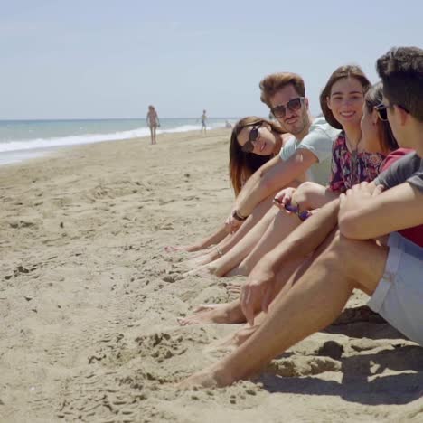 grupo de jóvenes amigos de moda sentados en una playa