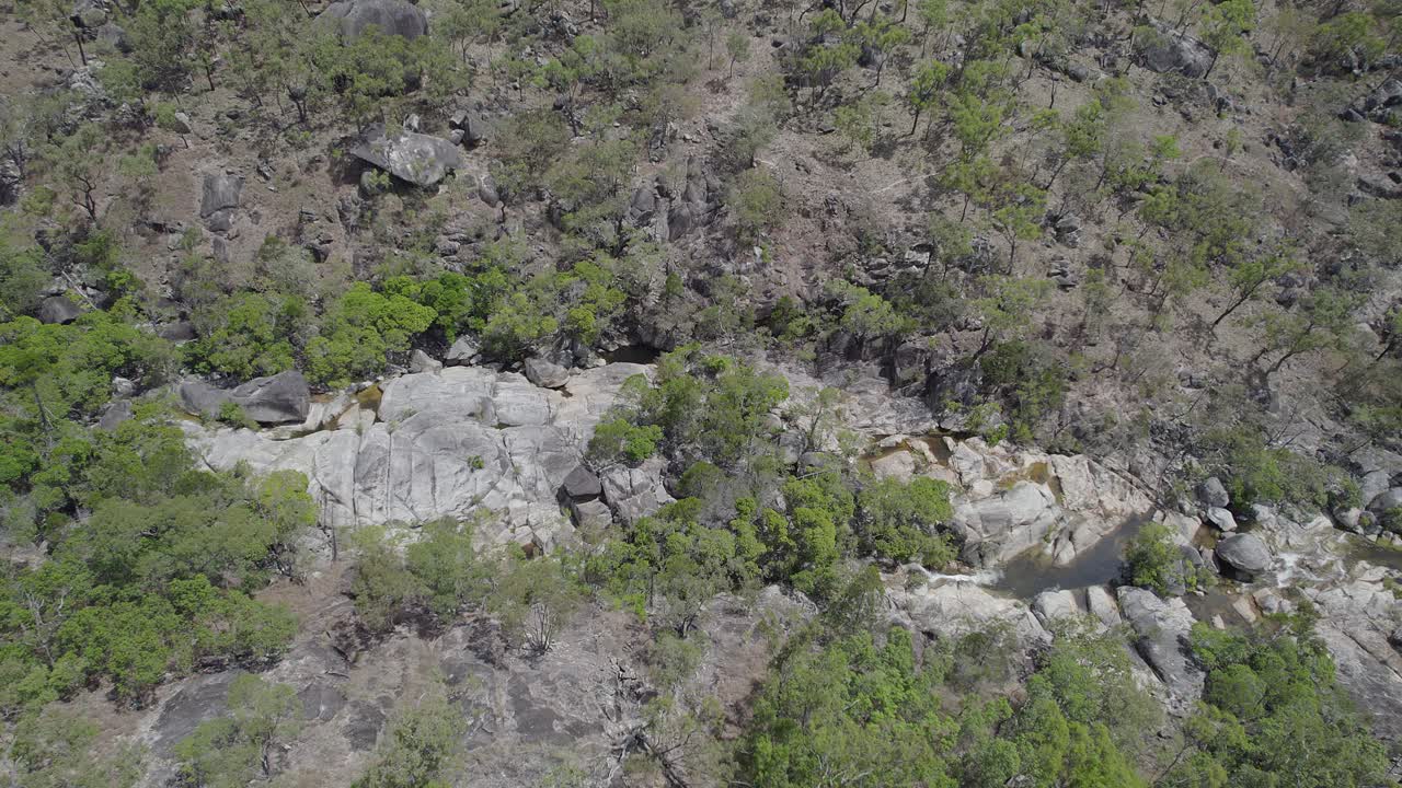 cataratas de emerald creek rodeadas de rocas de granito y vegetación verde en mareeba, australia - toma aérea de drones