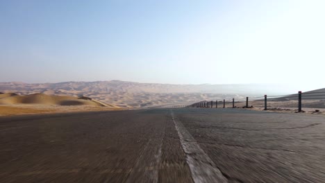 drone flies low down bumpy before ascending to reveal majestic desert sand dunes and blue sky