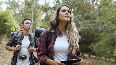 couple of young backpackers walking in forest