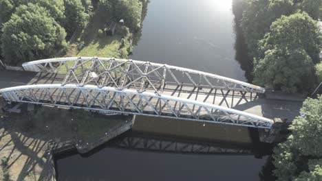 scenic birds eye orbit right above car crossing old-fashioned steel arched traffic footbridge over manchester ship canal at sunrise