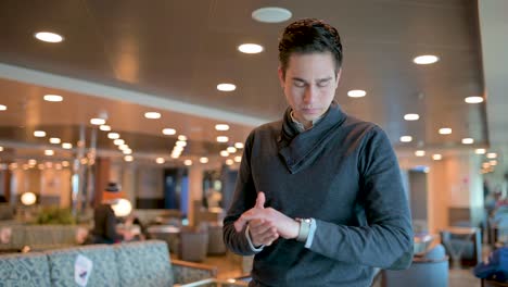 worried man checking time on wristwatch