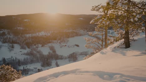 Sunset-at-the-peak-of-a-snowcovered-mountain-in-Norway-with-a-beautiful-view-of-another-mountain-filled-with-trees-and-snow-and-a-lot-of-colors