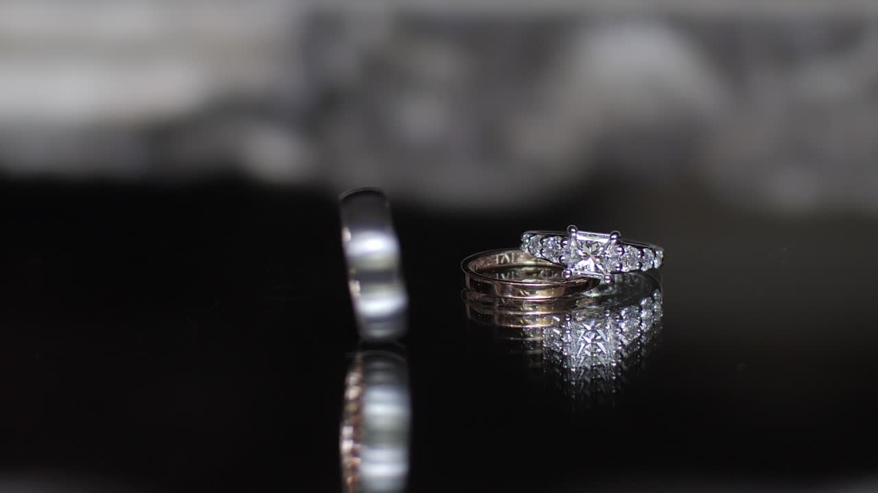 Elegant wedding rings on reflective surface