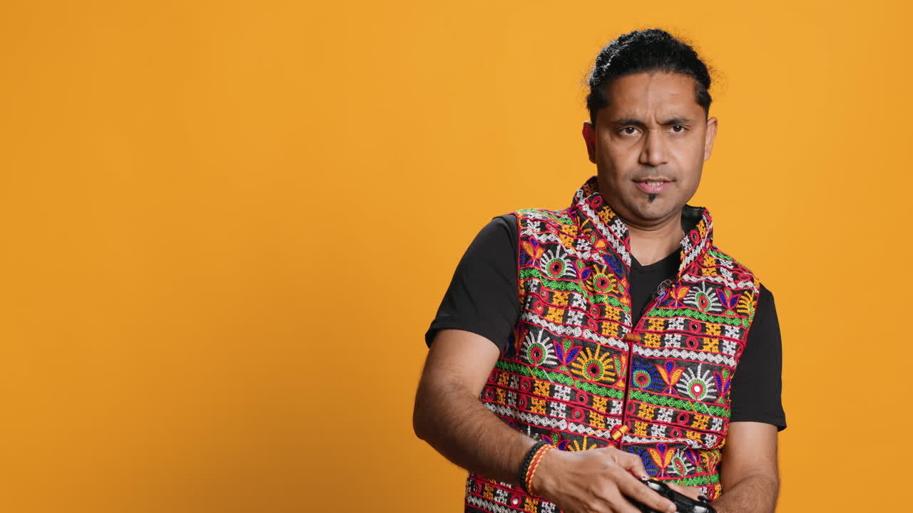 hombre disgustado contra el juego, haciendo el pulgar hacia abajo gesto, fondo de estudio