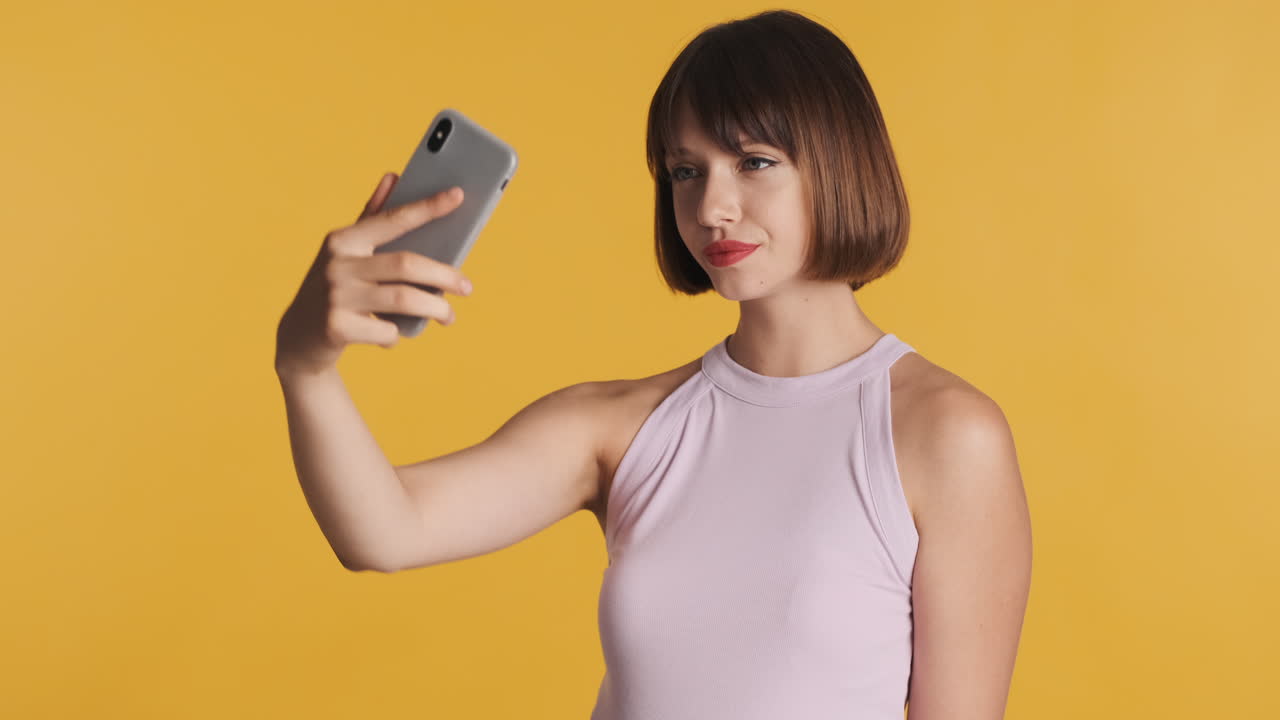 여성이 셀피 사진을 찍고 결과를 보고 있습니다.