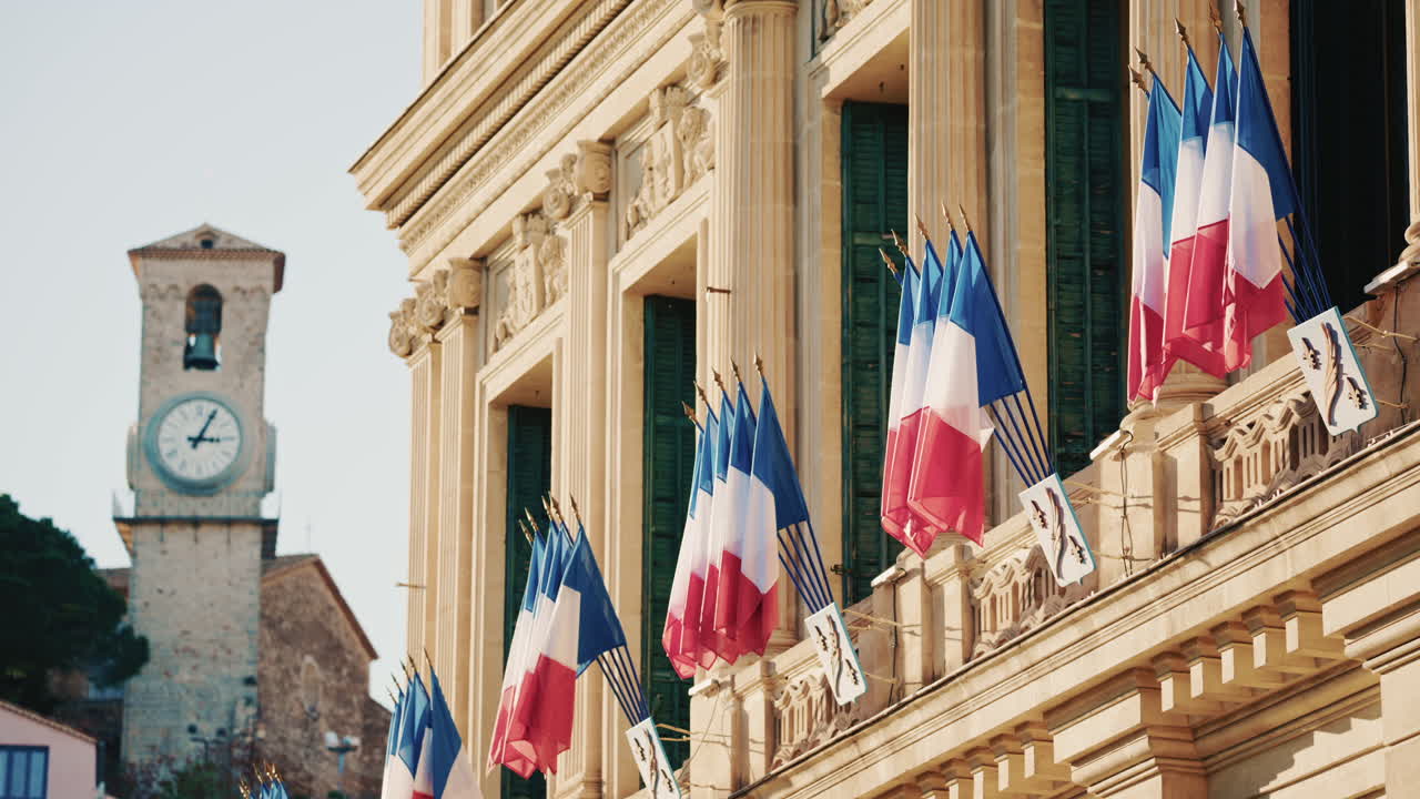Campo lungo di un edificio storico decorato con bandiere tricolori francesi in una giornata limpida