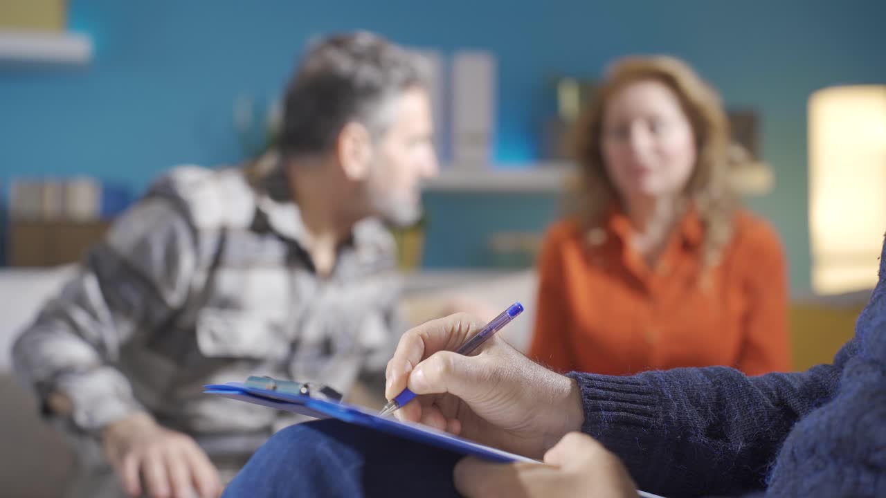 el psiquiatra toma notas mientras la pareja casada discute problemas familiares.