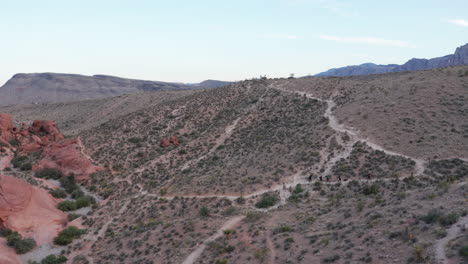 Toma-Aérea-Amplia-De-Excursionistas-En-El-Sendero-En-El-Pintoresco-Paisaje-Montañoso-Del-Desierto-Del-Sudoeste