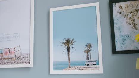 pictures on the wall showing see wiev beach with palms and the oldschool camper van