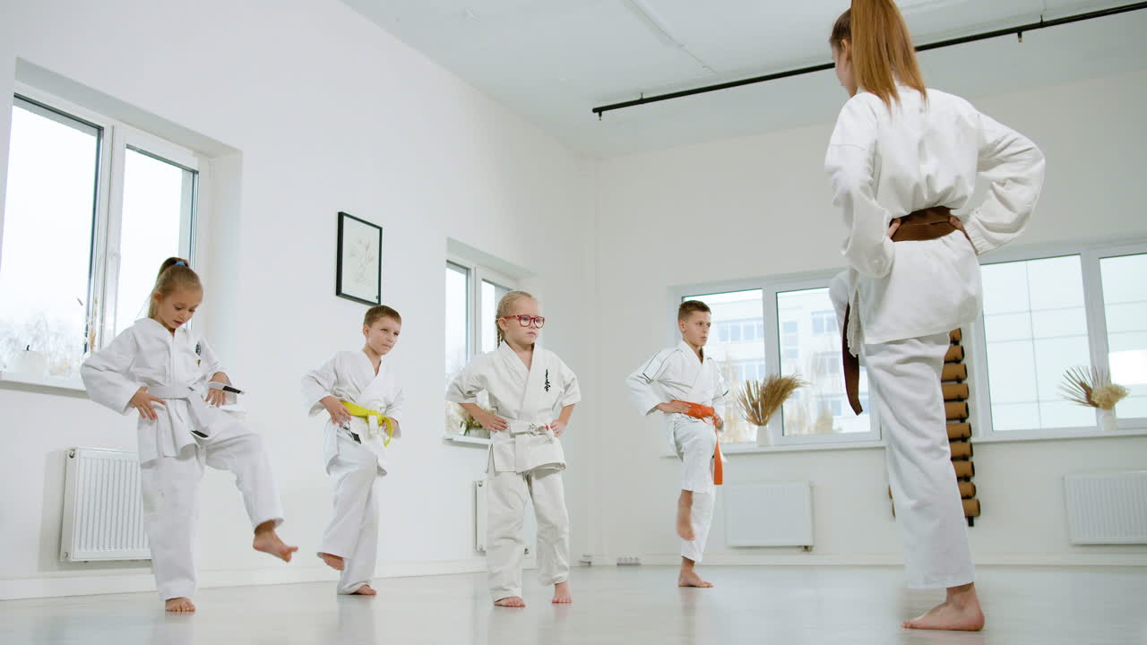 niños en kimono blanco en la clase de artes marciales