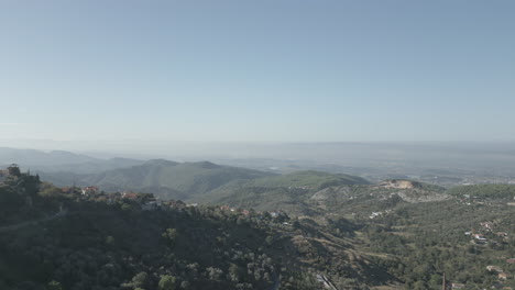 Drohnenschuss-Von-Oben-Kruje-Albanien,-Der-An-Einem-Bewölkten-Tag-über-Die-Stadt-Auf-Der-Klippe-Fliegt,-Mit-Wolken-Vor-Den-Bergen-Und-Einem-Blick-über-Das-Weit-Entfernte-Tirana