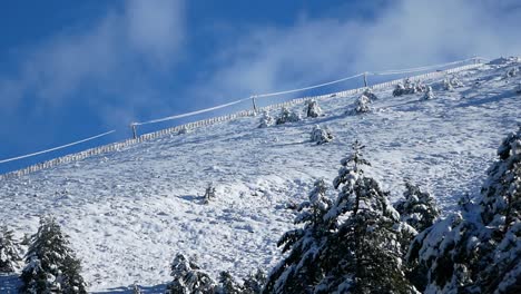 people in the distance climbing a snowy slope near a sky track