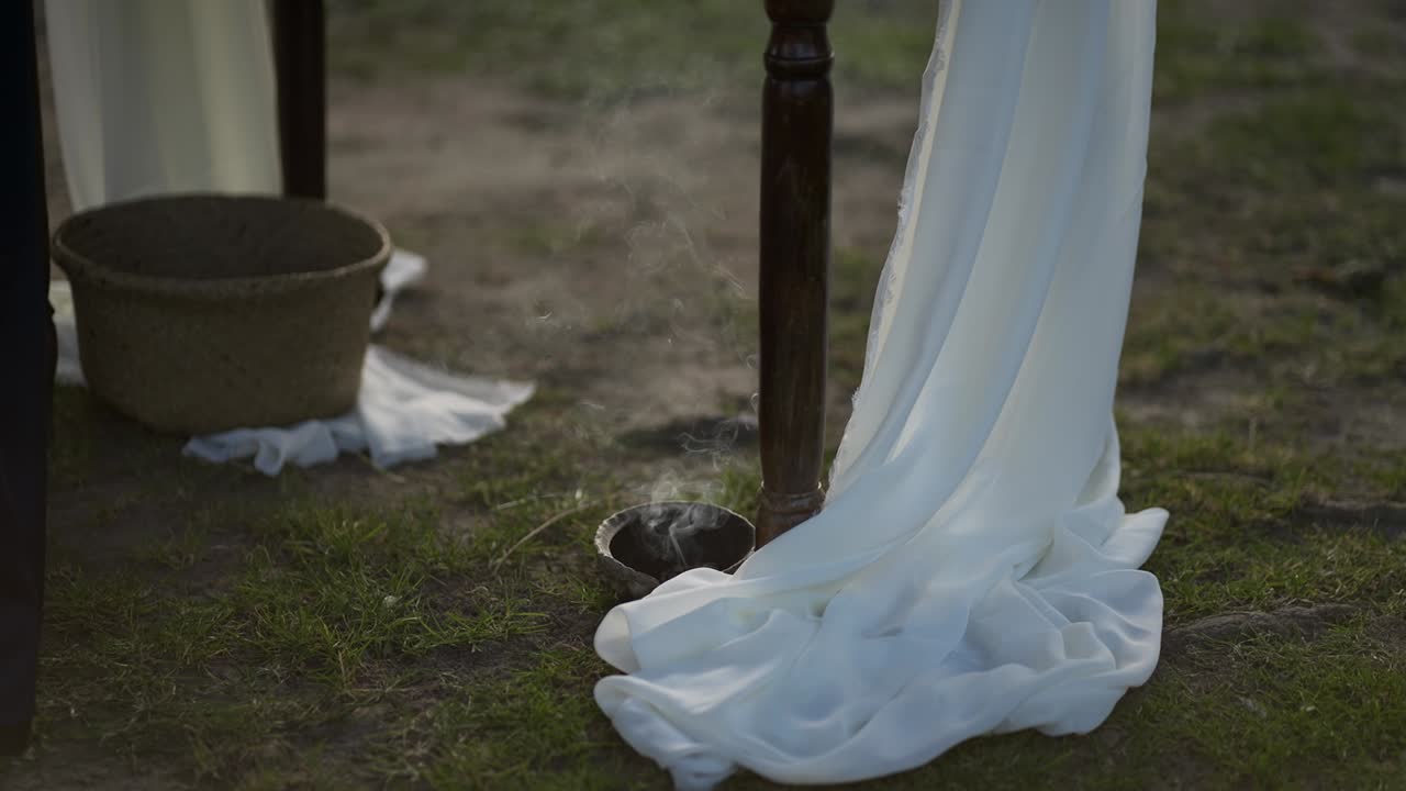 흰색 천이 야외에서 연기와 함께 땅에 닿는 장면을 슬로우 모션으로 자세히 보여주고 있어요