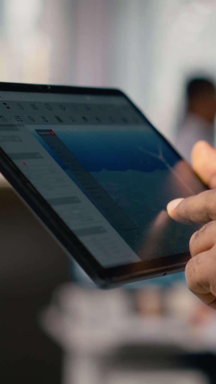 Close up of engineer in office using tablet to work on wind turbine CAD design