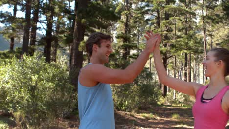 fit couple high fiving during jogging