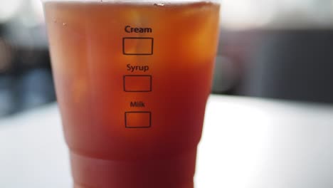 close-up of a cup of iced coffee with cream, syrup, and milk options