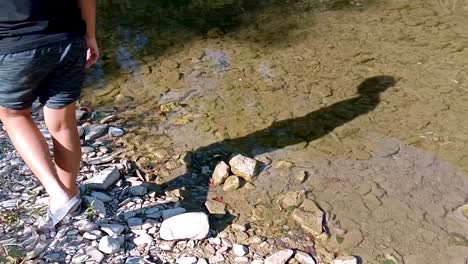 person walking along a riverbank